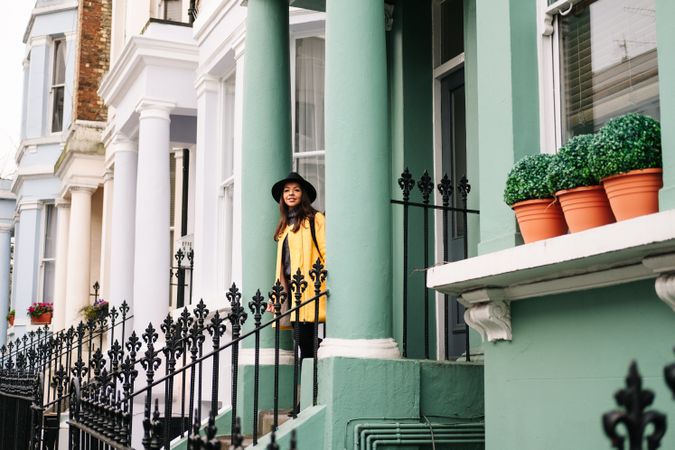Cheerful woman standing in stairs in typical london buildings