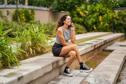 A woman sitting in a park talking on the phone