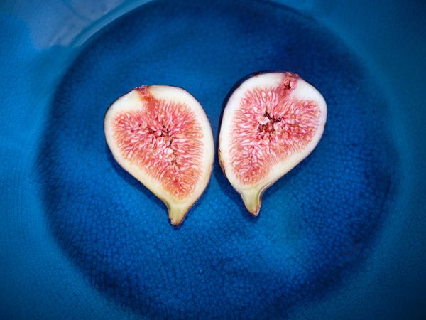 Closeup fig cut in half on blue plate