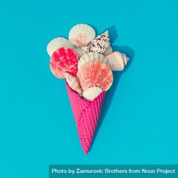 Sea shells in pink waffle cone on bright blue background 5aP2a0