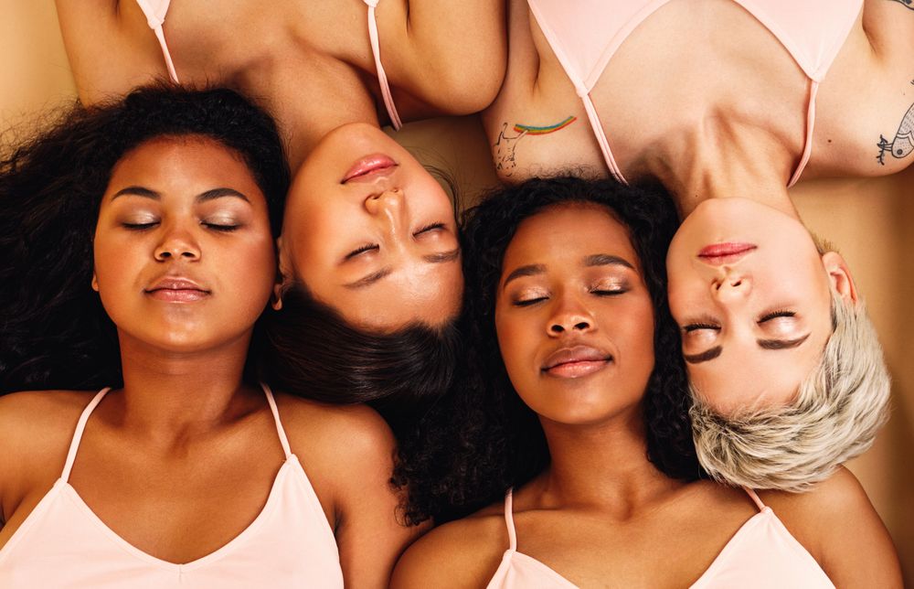Multi-ethnic friends lying with their heads together