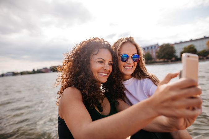 Female friends taking self portrait with mobile phone