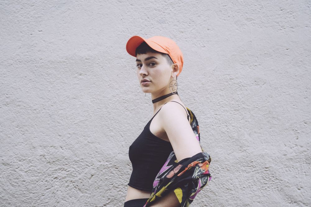 Woman in orange cap looking at camera sideways
