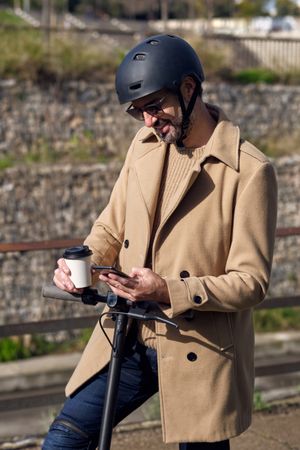 Man browsing smartphone on scooter