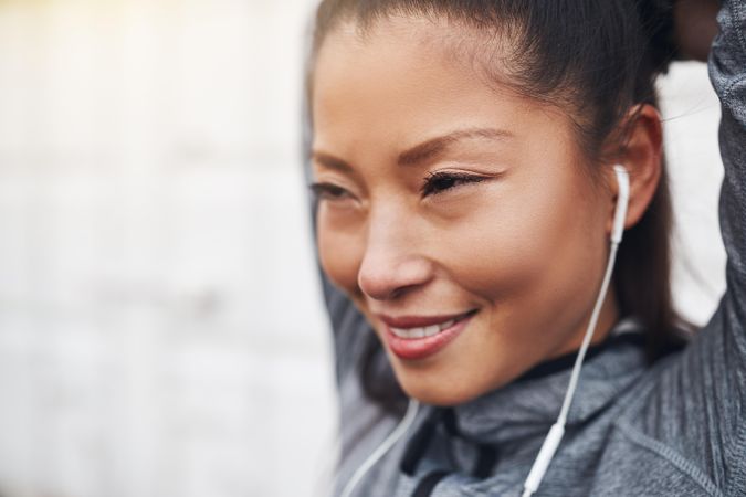 Happy woman stretching her biceps in workout gear