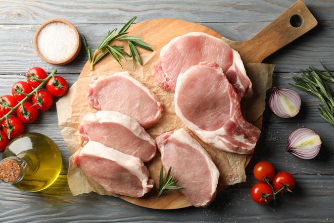 Composition with raw meat for steak and ingredients on wooden background