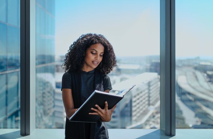 Focused female executive writing notes in notepad