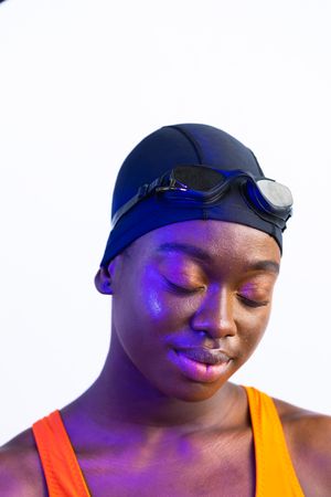 Portrait of female Black swimming with colorful lighting and plain background