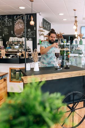 Skilled barista crafting specialty coffee with Japanese siphon coffee maker in modern cafe