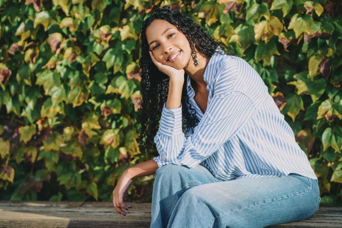 A Young Woman Relaxing Peacefully Against a Backdrop of Lush Greenery, Embracing Nature