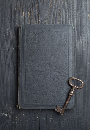 Top view vintage key over dark leather book cover
