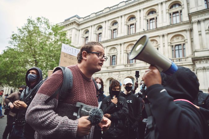 London, England, United Kingdom - June 6th, 2020: Man with microphone leans into woman