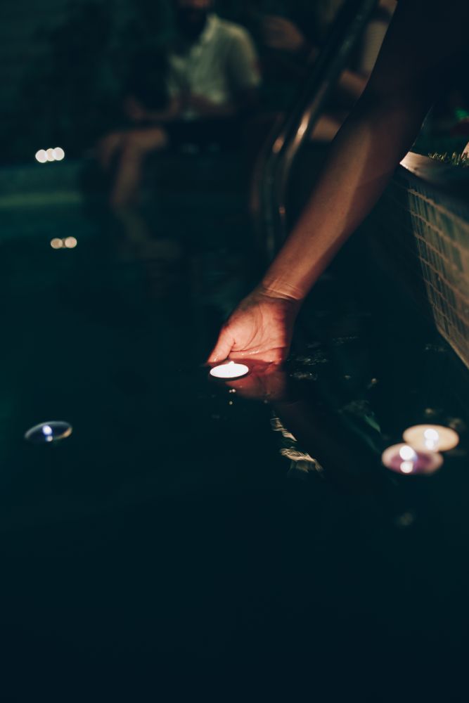 Woman swimming in pool with candles