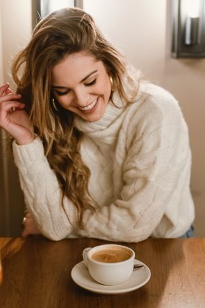 Elegant woman mixing coffee in cafe