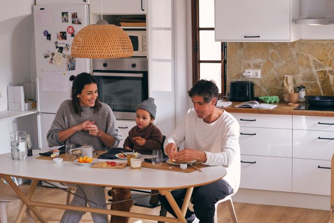 Family with little boy at table during breakfast at home