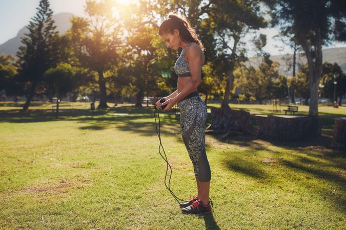 Full length shot of fit young woman with skipping rope outdoors at the park