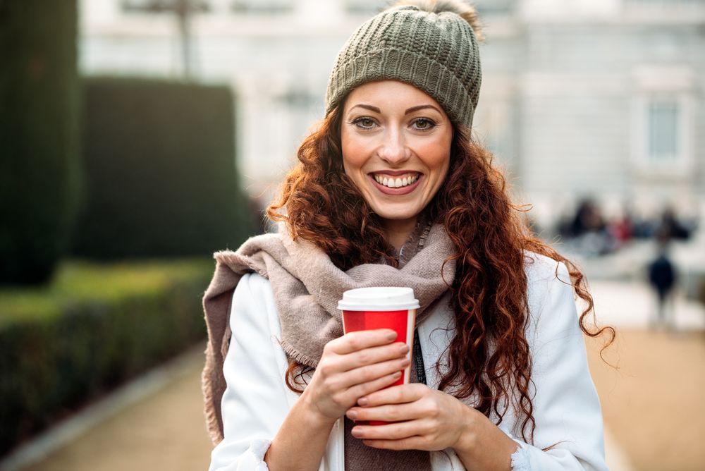 Beautiful woman drinking coffee in the streets of Madrid on winter