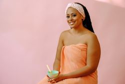 Portrait of a woman in spa towel with bowl of product
