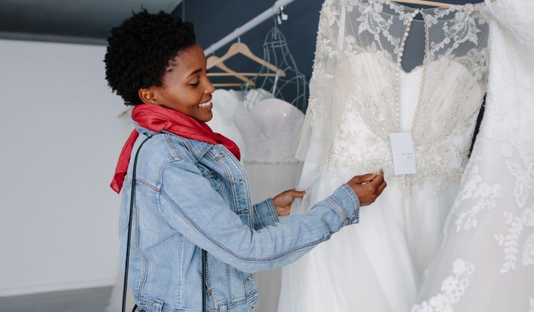 Smiling Black woman shopping for wedding outfit in bridal boutique