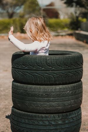 Anonymous girl standing in stack of tires