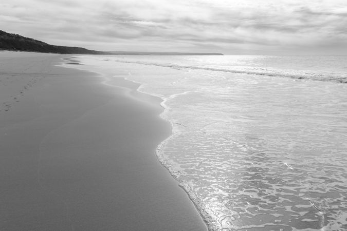 Footprints on an empty beach on overcast day