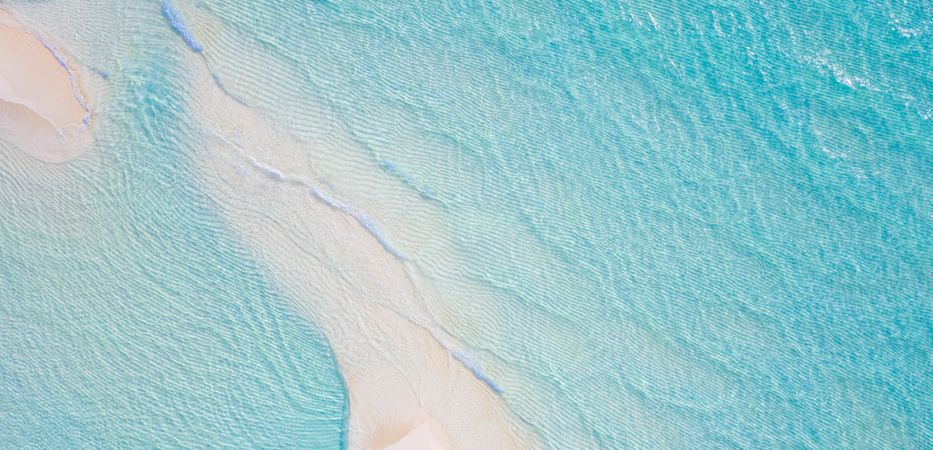 Wide shot of clear blue water and sand in the Indian Ocean, wide