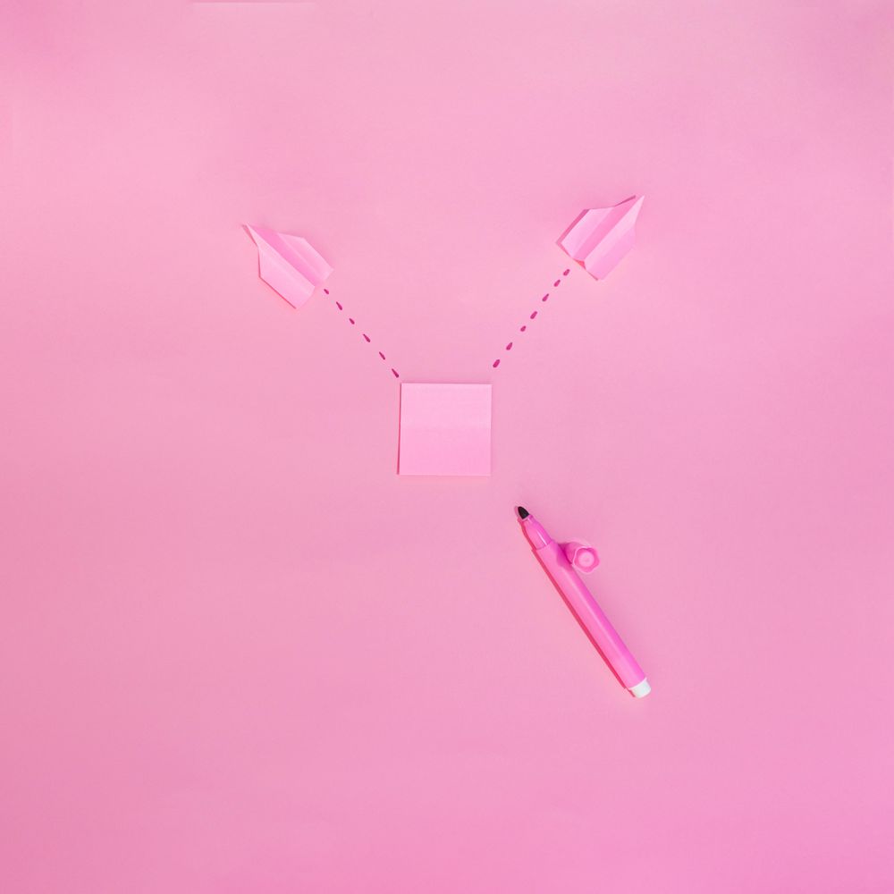 Pen and post it notes on pink background