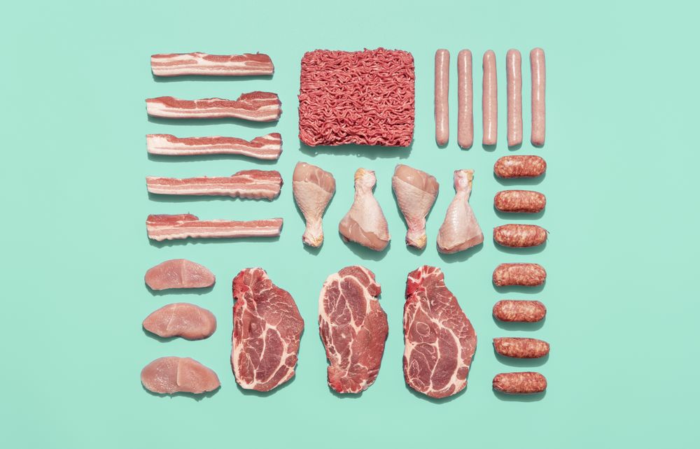 Raw meat variety isolated on a green background, top view