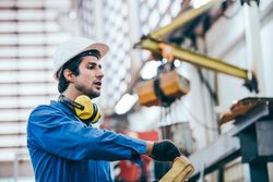 Mechanical engineer using equipment to control machine in industrial factory