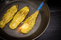 Person cooking endive with burner in pan