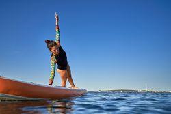 Young woman standing in Side Plank on SUP board