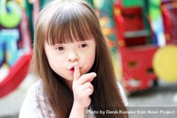 Young girl with Down syndrome saying “shh” 5kQ9Gb