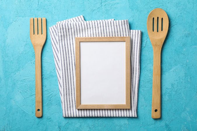 Kitchen cutlery, napkin and blank space for text on blue background