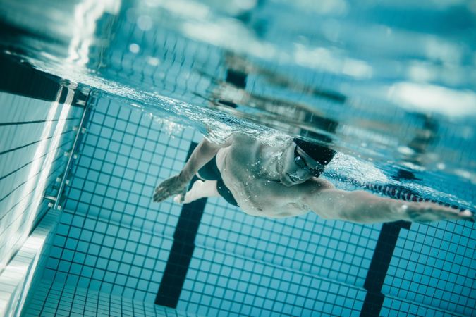 Professional male swimmer underwater in swimming pool