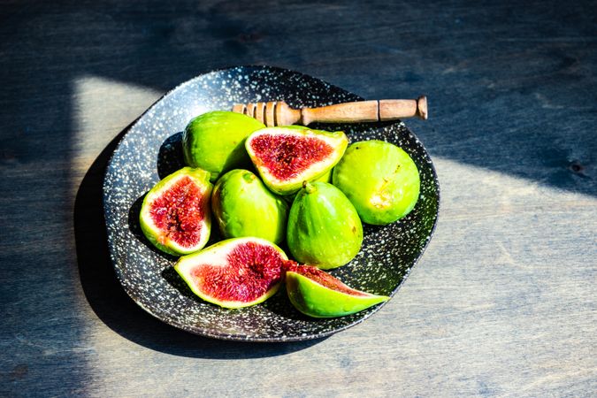 Top view of fresh figs on plate in sunny kitchen