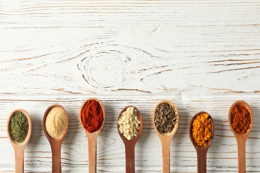 Row of wooden spoons full of spice with copy space