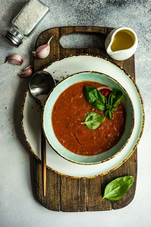 Top view of traditional gazpacho soup with olive oil, basil, garlic and pepper