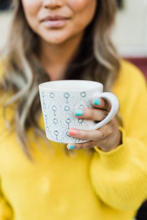 Woman in yellow sweater holding mug