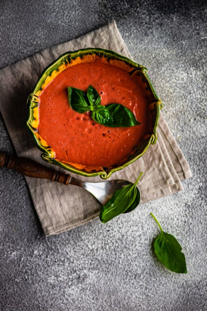 Top view of traditional tomato soup with herb garnish