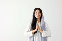 Young Indonesian Muslim Woman Wearing Hijab Scarf Gesturing Eid Mubarak Greeting