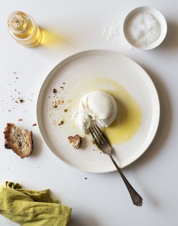 Plate with cheese near bread and condiments