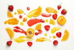 Apricot, strawberry, orange and jams on plain background