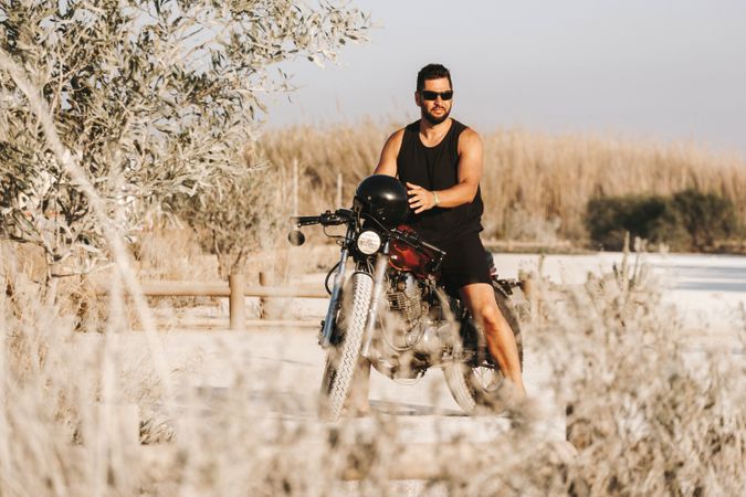 Serious male driving motorcycle in forest
