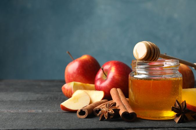 Apples, anise, cinnamon stick honey on table with copy space