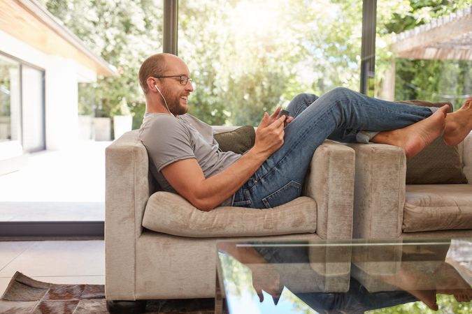 Side view image of a happy  man using digital tablet at home