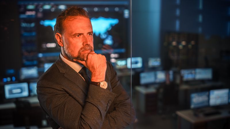 Contemplative Executive in Control Room, Analyzing Global Data.