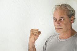 Portrait of middle aged man in gray shirt holding a fist