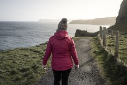 Woman standing on country road admiring views