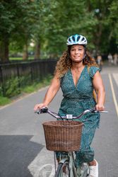 Smiling Black woman riding bike through city 5XeWk4
