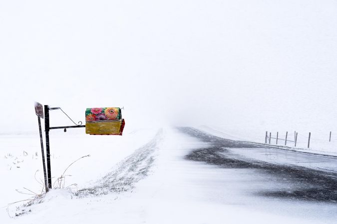 Colorfully decorated floral mail box on a snowy road